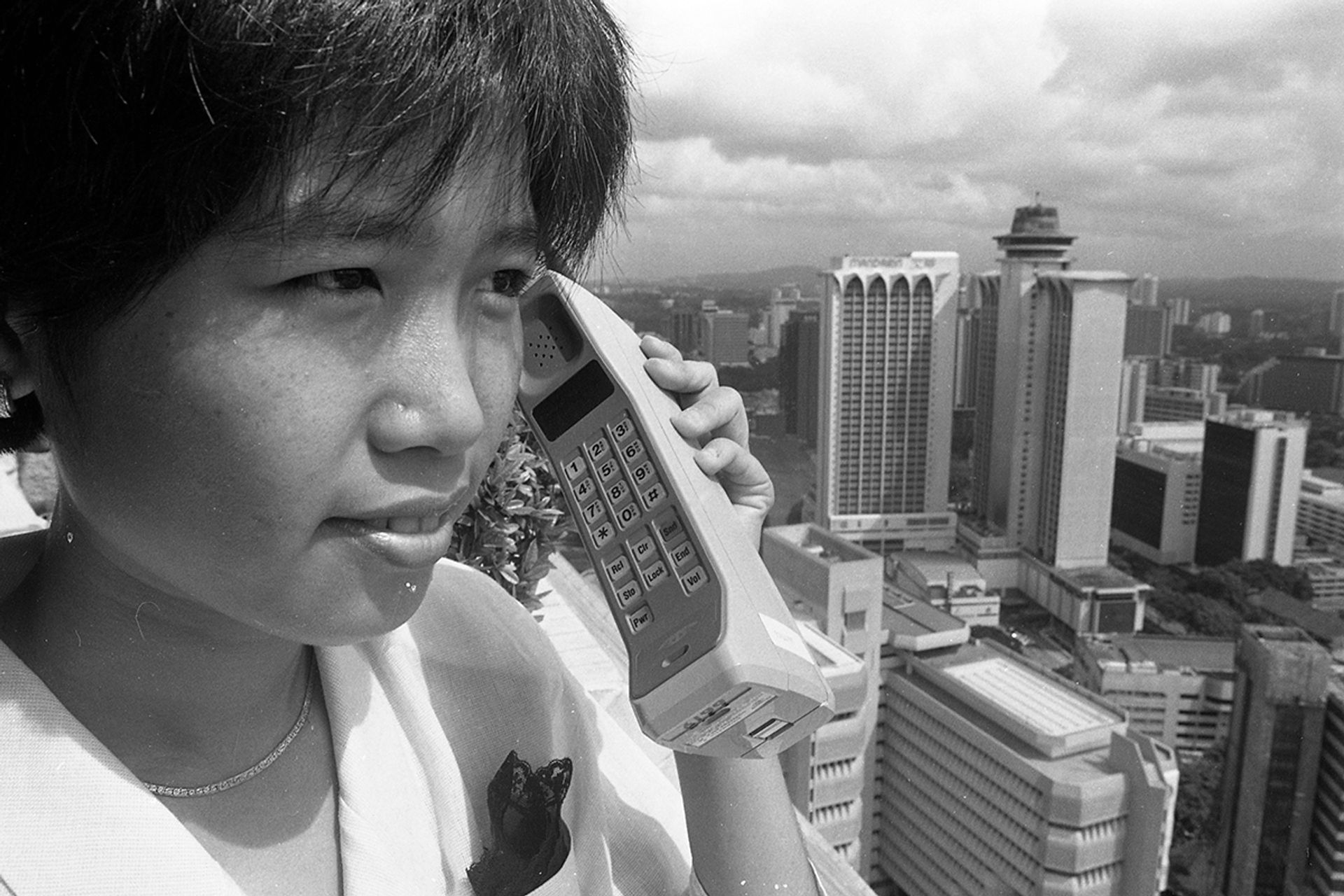 Telecoms officer Yen Ee Wen holding the brick phone in this photo taken on Aug 15, 1988. ST FILE PHOTO: YAP YEW PIANG
