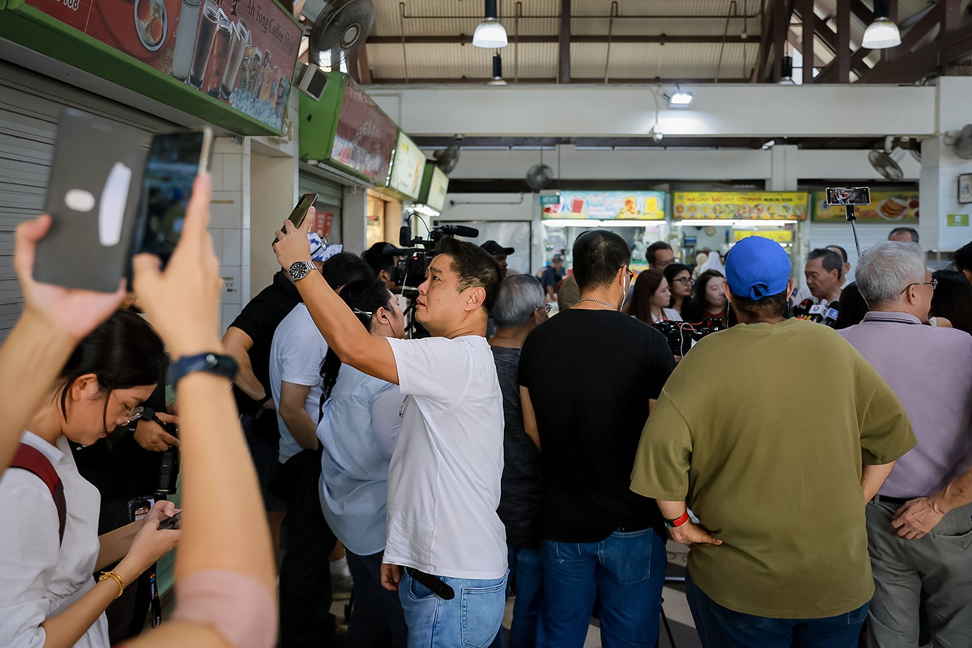 People taking pictures of Mr Tan at Geylang Serai Market and Food Centre on Aug 25, 2023.  ST PHOTO: GAVIN FOO
