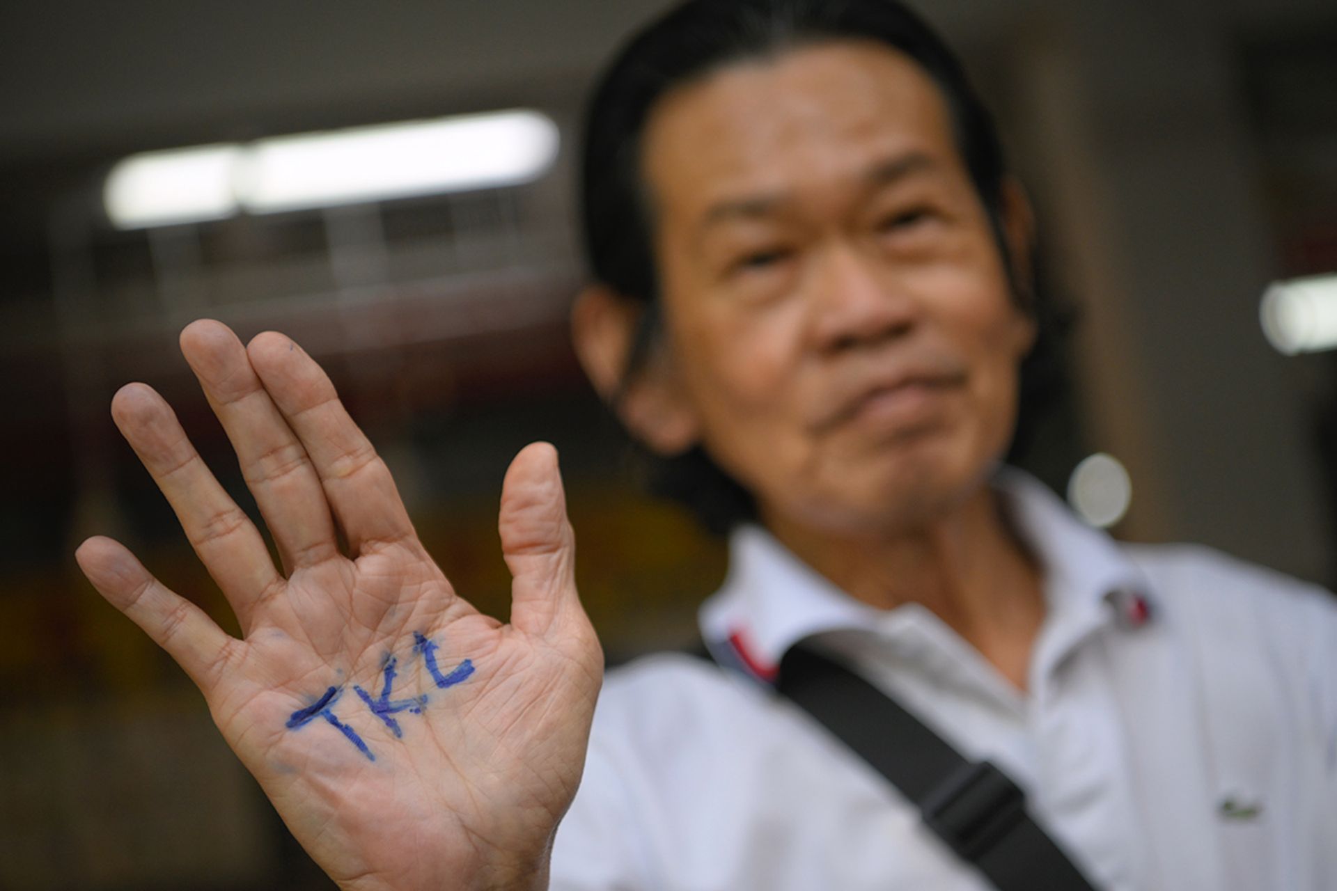 A man at People’s Park Food Centre displaying his support for Mr Tan as he flashes the initials “TKL” written on his palm on Aug 27, 2023. ST PHOTO: MARK CHEONG