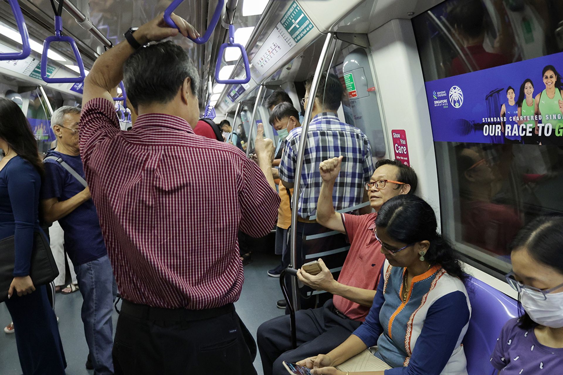Mr Tan giving a thumbs up to an MRT commuter on the North East Line on Aug 14, 2023. ST PHOTO: GIN TAY