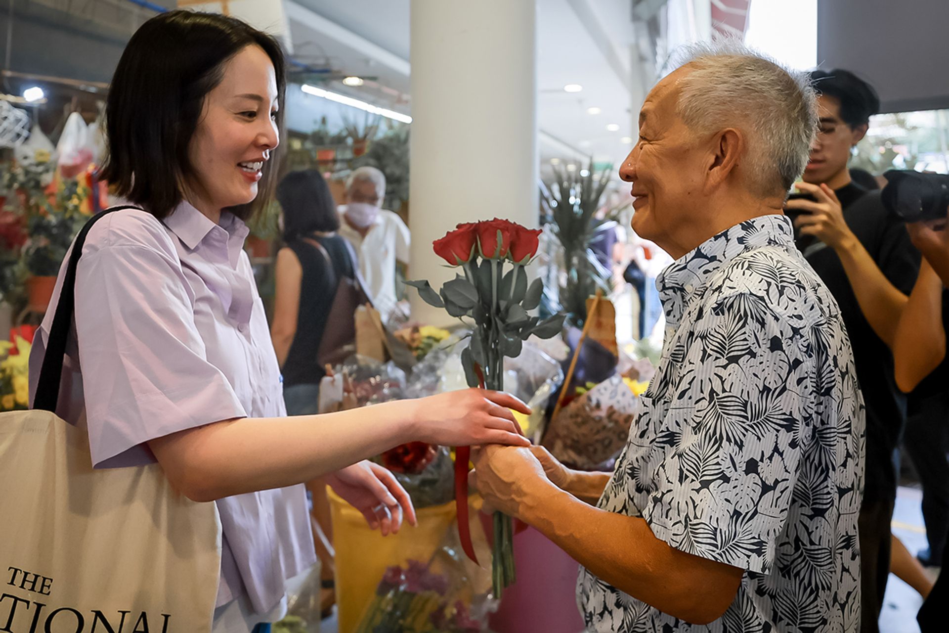 Mr Ng giving his fiancee Sybil Lau roses he got from a stall at Tiong Bahru Market and Food Centre on Aug 5, 2023. ST PHOTO: GAVIN FOO