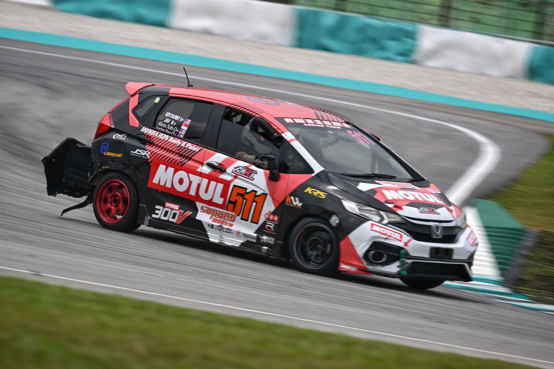 The No. 511 Honda Jazz of Team Awesome Racing hurtling on, even after its rear bumper was damaged.